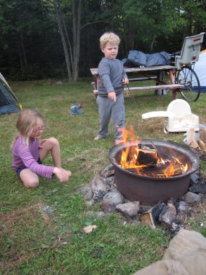 Harvey and Taya feeding the campfire with twigs