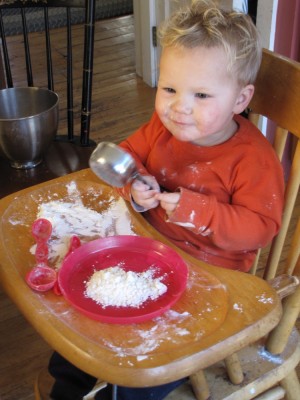 Lijah in the high chair making a mess with flour