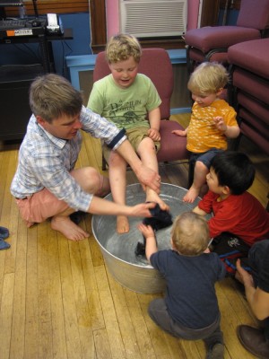 me washing Harvey's feet at church, with other kids looking on