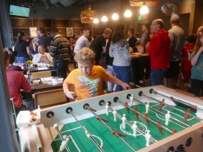 Harvey playing foozball at a crowded party