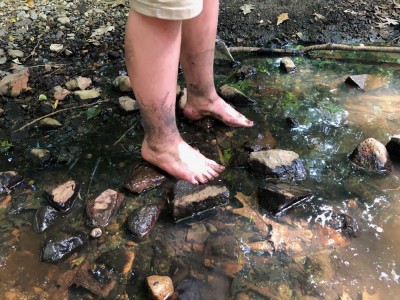 Harvey's muddy feet wading in a shallow stream