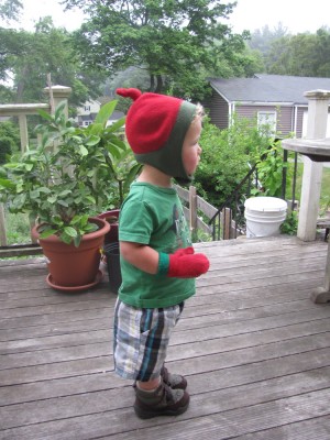 Lijah on the back porch wearing hat and mittens