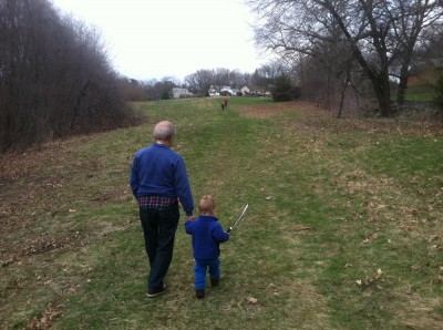 Lijah with his sword walking with grandpa in a field, the other boys up ahead