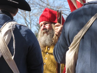 a bearded reenactor in a red cap