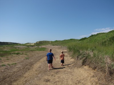 Harvey and Zion walking on a path by a dune