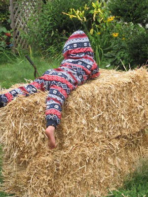 Lijah lying on hay bales in his (Zion's actually) pajamas