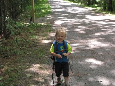 Lijah looking proud wearing Zion's backpack on the trail
