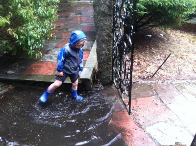 Zion kicking water in a giant puddle