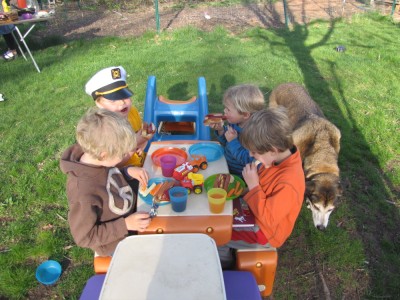 boys and friends at the little picnic table eating hot dogs