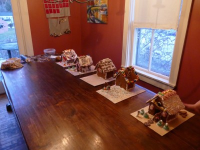 five finished gingerbread houses lined up on the table