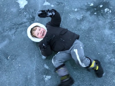 Lijah on his back sliding on the ice