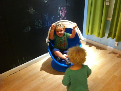 Harvey in a modernist kids chair, Zion waiting his turn