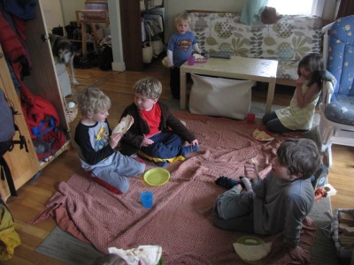 Archibald and Stevens kids eating a picnic on a blanket in the playroom
