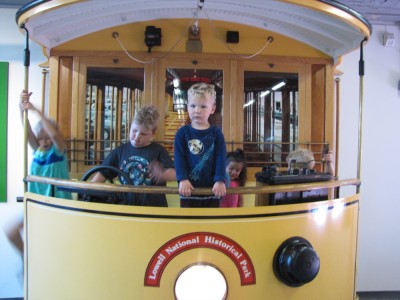 the kids playing on a replica trolley in the museum
