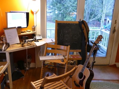 my desk set up with microphone and guitar and propped-up notes