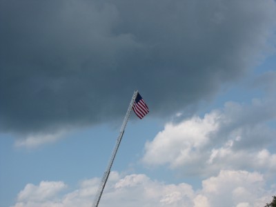 an American flag held high aloft on a fire-engine's ladder