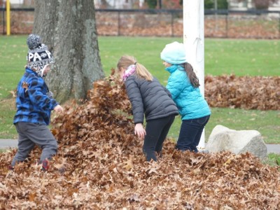 Zion and friends burying someone in leaves