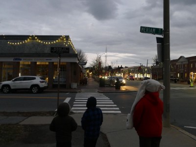 the boys walking towards the Christmas-lighted Lexington commercial stretch