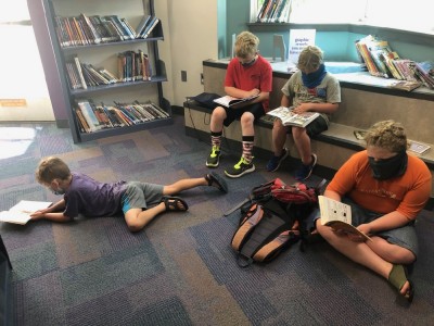 the boys and a friend reading graphing novels at the library