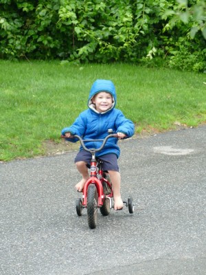 Lijah riding a bike with training wheels