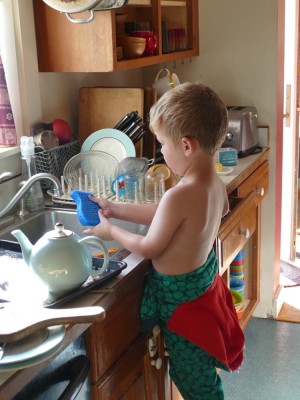 Lijah washing the dishes in his PJs
