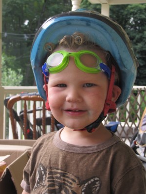 Lijah with his bike helmet on and swim goggles pushed up on his forehead