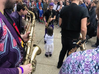 a young girl amidst the Party Band saxophonists