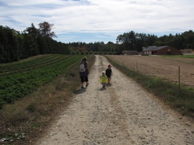 Mama, Zion, and Harvey walking down the path towards the apple trees