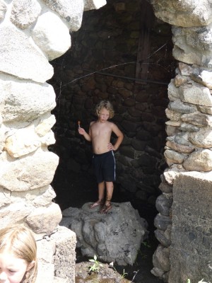 shirtless Elijah in the doorway of the stone boathouse at Fairhaven Bay