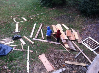 Harvey and Zion making roads and ramps for little cars out of the piles of lumber on the lawn