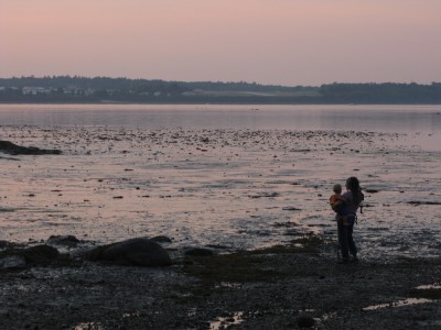 Leah, holding Lijah, watching the sunset at low tide