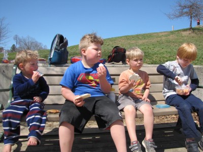 the boys eating matzah sandwiches at a playground