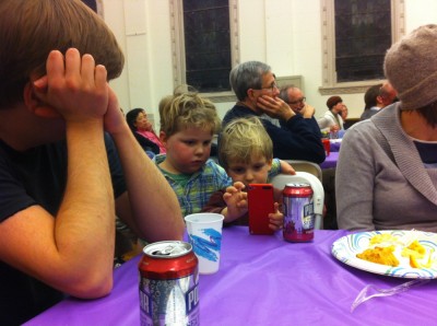 Harvey and Eliot sharing an iPhone during a church meeting