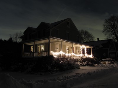 our house, with Christmas lights, in the snow