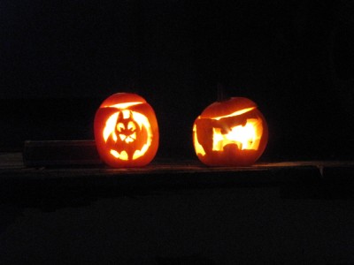 glowing jack-o-lanterns: a bat and an H carved and illuminated in little pumpkins