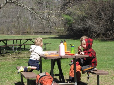 the three boys eating at a picnic table
