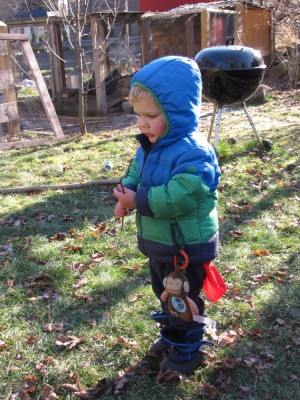 Lijah outside with a monkey toy hanging from his coat pocket