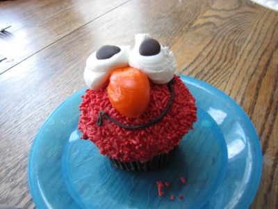 a giant cupcake frosted like a happy red monster