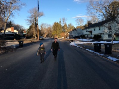 Harvey and Zion walking on the street with long shadows behind them