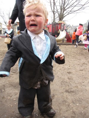 Lijah crying, with mud all over the front of his suit