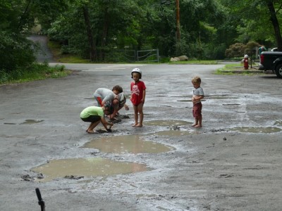 the boys with friends playing in a muddy parking lot