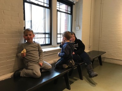 the boys eating a snack in the bare lobby of the HMNH