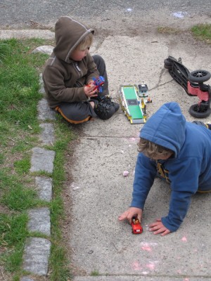Harvey and Zion playing with legos on the front walk