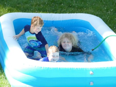 the boys splashing in an inflatable pool
