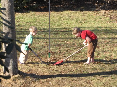 Harvey and Zion, barefoot and short-sleeved, digging in the lawn