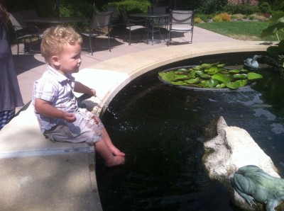 Lijah sitting on the side of the koi pool at the nursing home