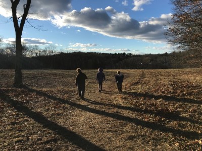Harvey, Zion, and Nisia walking in a field