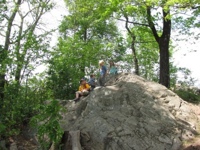 the kids atop a mountainous boulder
