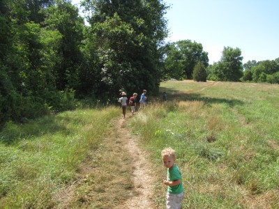Lijah following behind the other kids on a meadowy hike