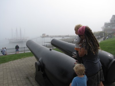 Zion, Mama, and Lijah looking down the cannons at the fog-bound ships